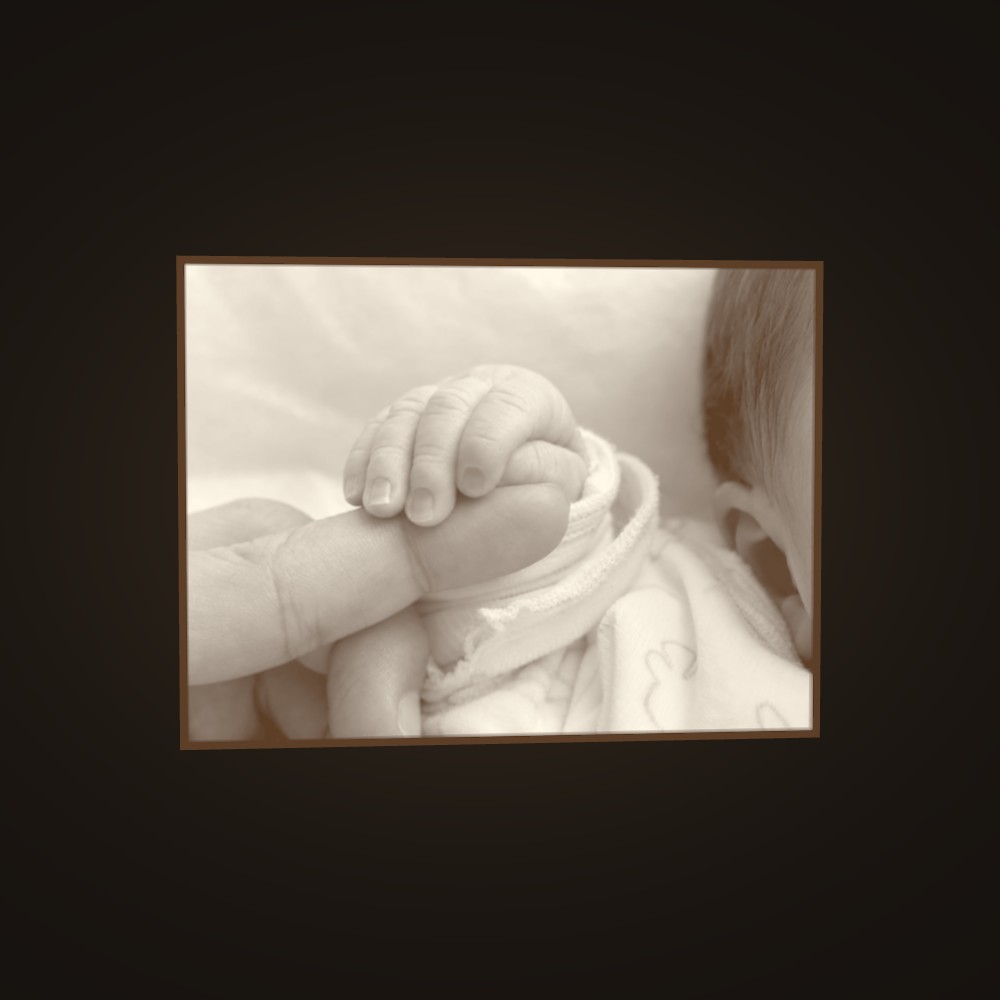A baby’s hand, lit